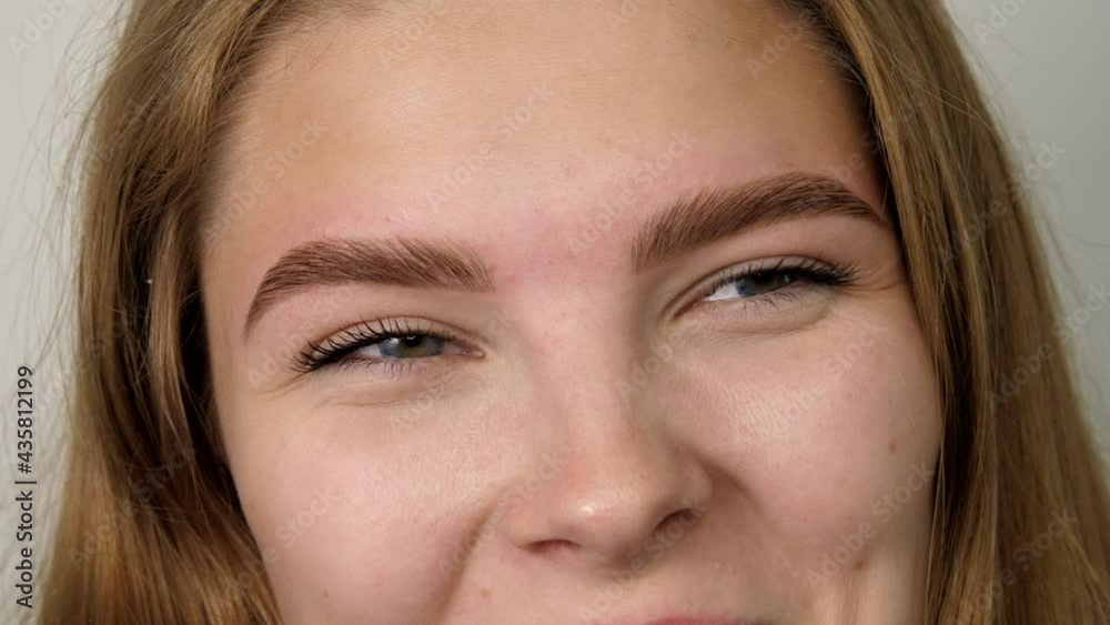 Happy girl smiling face looking at camera. Head shot close up portrait. Beautiful young human face with white skin. Female nature beauty. Woman laughs and playfully looks at the camera Happy girl smiling face looking at camera. Head shot close up portrait. Beautiful young human face with white skin. Female nature beauty. Woman laughs and playfully looks at the camera