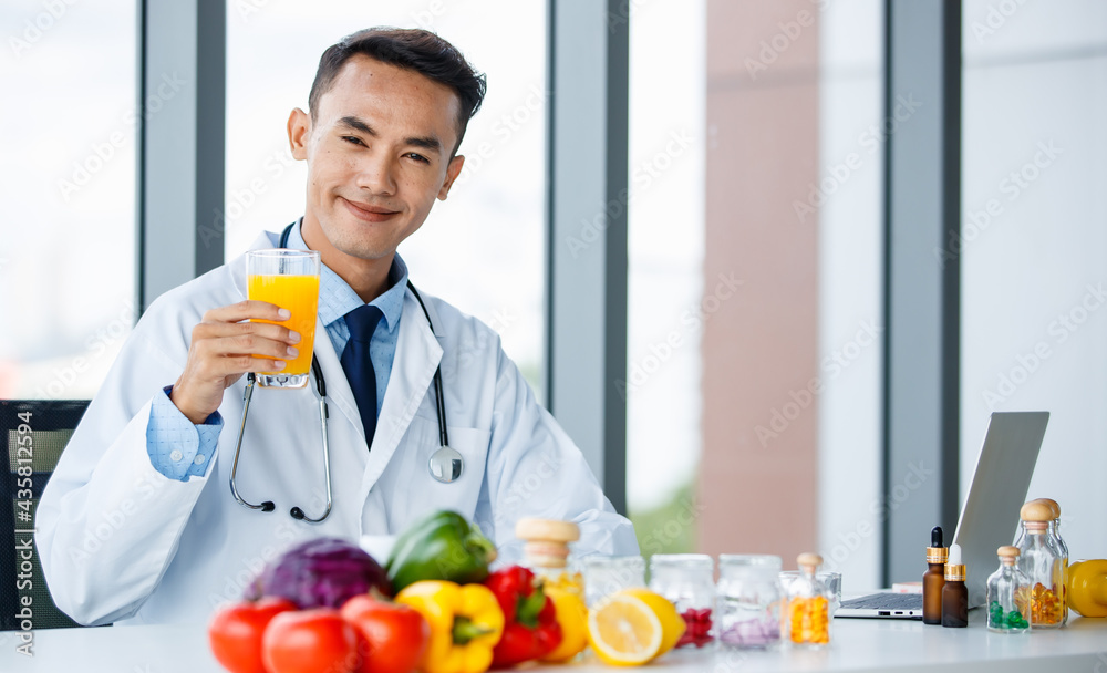 Asian nutritionist showing orange and juice Asian nutritionist showing orange and juice
