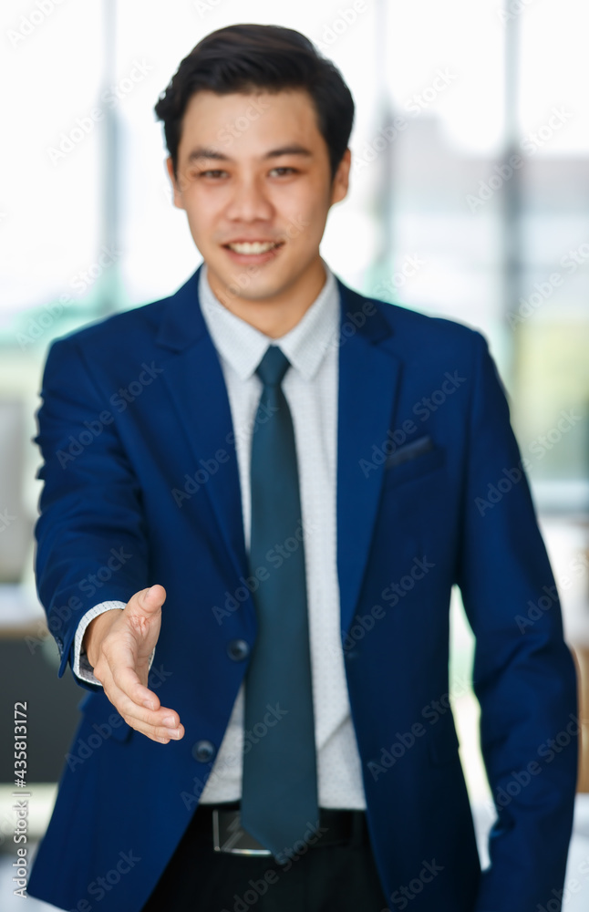 Cheerful Asian businessman reaching out hand for handshake Cheerful Asian businessman reaching out hand for handshake