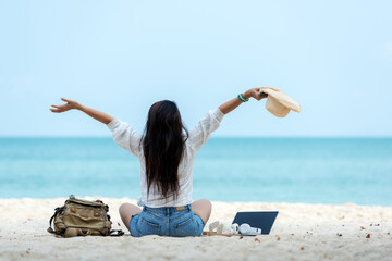 Lifestyle freelance woman raise arms relax after using laptop working on the beach.  Asian people success and together your work pastime and meeting conference on internet in holiday