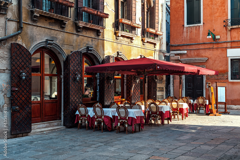 Outdoor restaurant on small square in Venice, Italy. - obrazy, fototapety, plakaty 