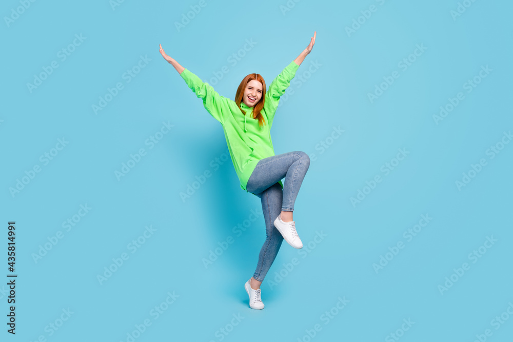 Full length body size view of attractive cheerful ecstatic girl dancing having fun isolated over bright blue color background Full length body size view of attractive cheerful ecstatic girl dancing having fun isolated over bright blue color background