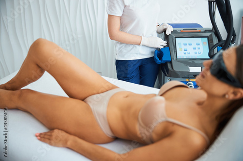 Female patient in underwear relaxing before a laser therapy session