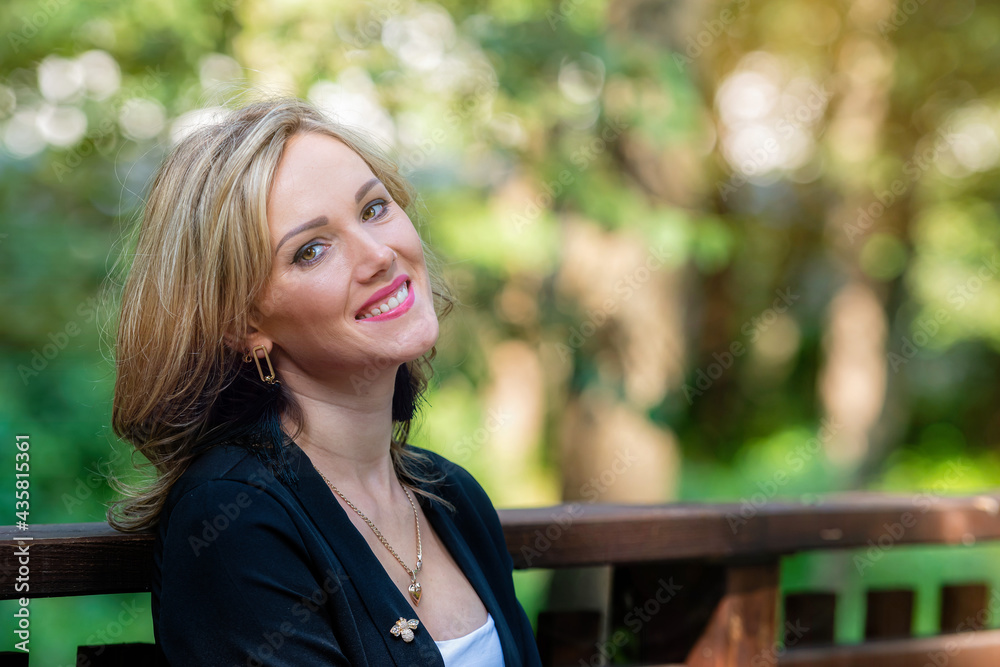 fashion portrait of a stylish nice blonde female on a defocused park background fashion portrait of a stylish nice blonde female on a defocused park background