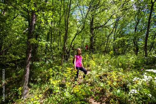 Portrait of adorable hiking little girl on spring day in forest