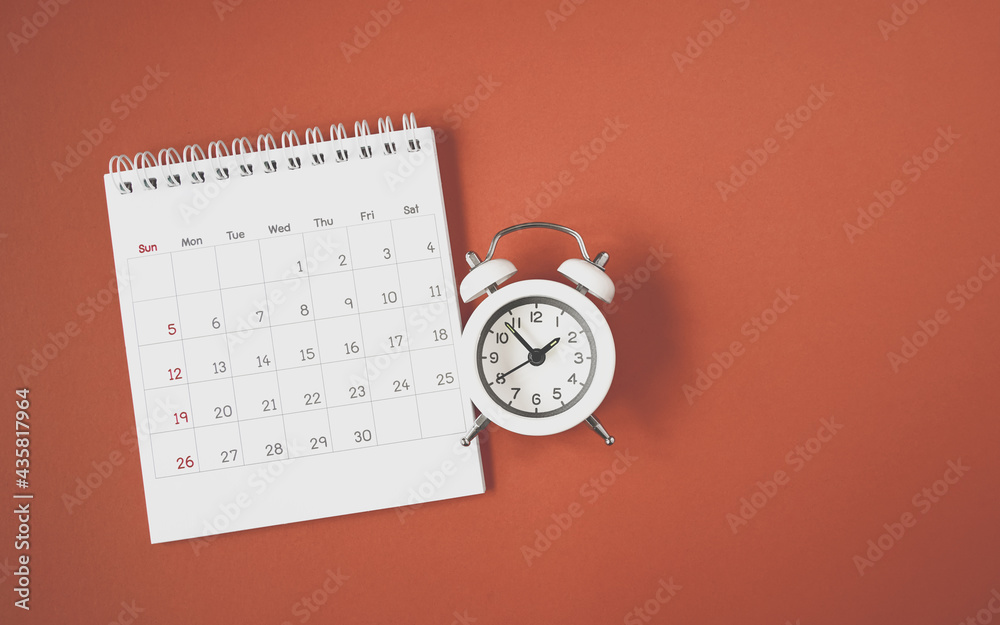 white analog clock and opened calendar on grunge dark orange background with copy space , planning for business meeting or travel planning concept white analog clock and opened calendar on grunge dark orange background with copy space , planning for business meeting or travel planning concept