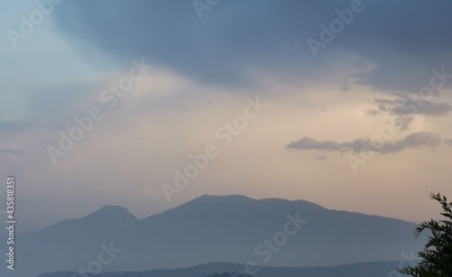 Montagne dell’appennino in un azzurro e luminoso tramonto di nuvole e foschia