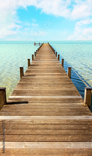 boardwalk to the horizon  tropic sea and light blue sky