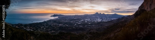 Beautiful panorama of the sunset from the mountain. Privileged views of Altea, Benidorm and Alicante from the top of a mountain. Sunset on the mountain, while the sun illuminates the Alicante coast © Hector
