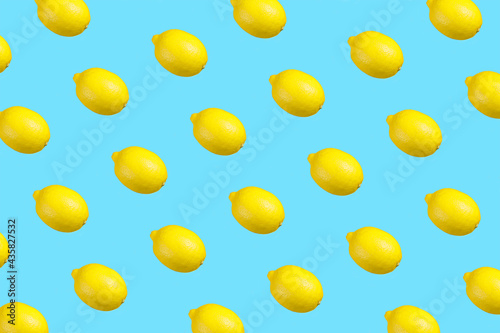 Colorful repetitive pattern made of isolated lemons on bright aqua blue background