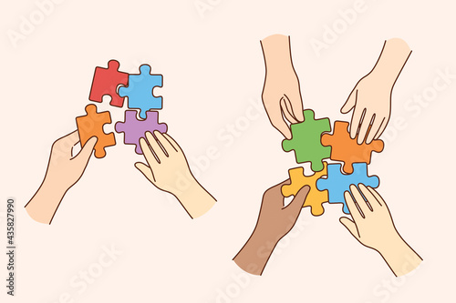 Teamwork, multi ethnic team, cooperation concept. Hands of multicultural people business partners workers colleagues firming whole puzzle of colorful pieces together meaning collaboration 