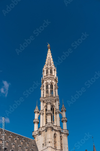 Brussels, Belgium. Town hall tower in the Gothic style against the blue sky.