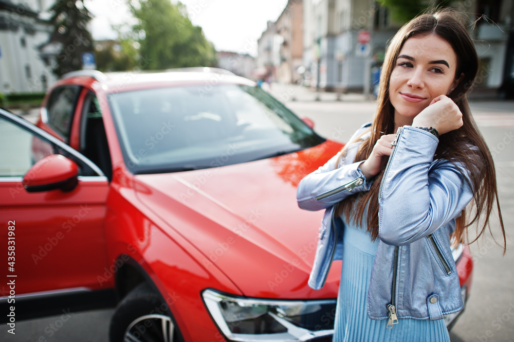 Outdoor photo of gorgeous woman posing near orange suv car. Outdoor photo of gorgeous woman posing near orange suv car.