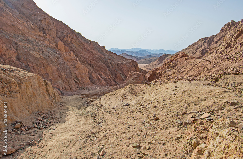 Canyon in barren desert landscape in hot climate