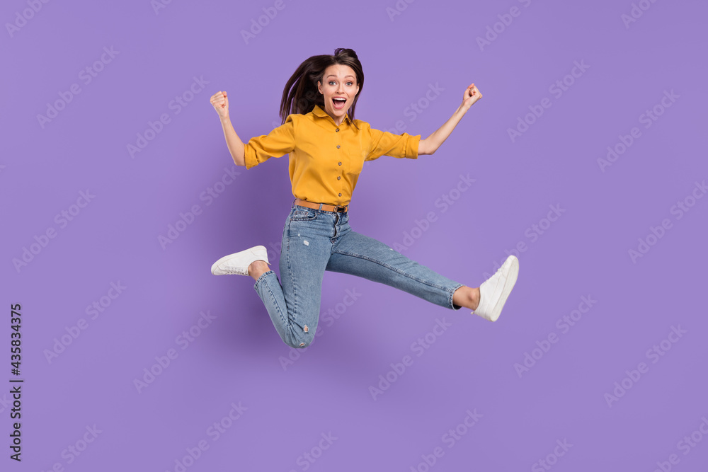 Full length body size photo jumping girl smiling overjoyed gesturing like winner isolated pastel purple color background