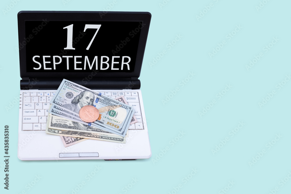 Laptop with the date of 17 september and cryptocurrency Bitcoin, dollars on a blue background. Buy or sell cryptocurrency. Stock market concept. Laptop with the date of 17 september and cryptocurrency Bitcoin, dollars on a blue background. Buy or sell cryptocurrency. Stock market concept.