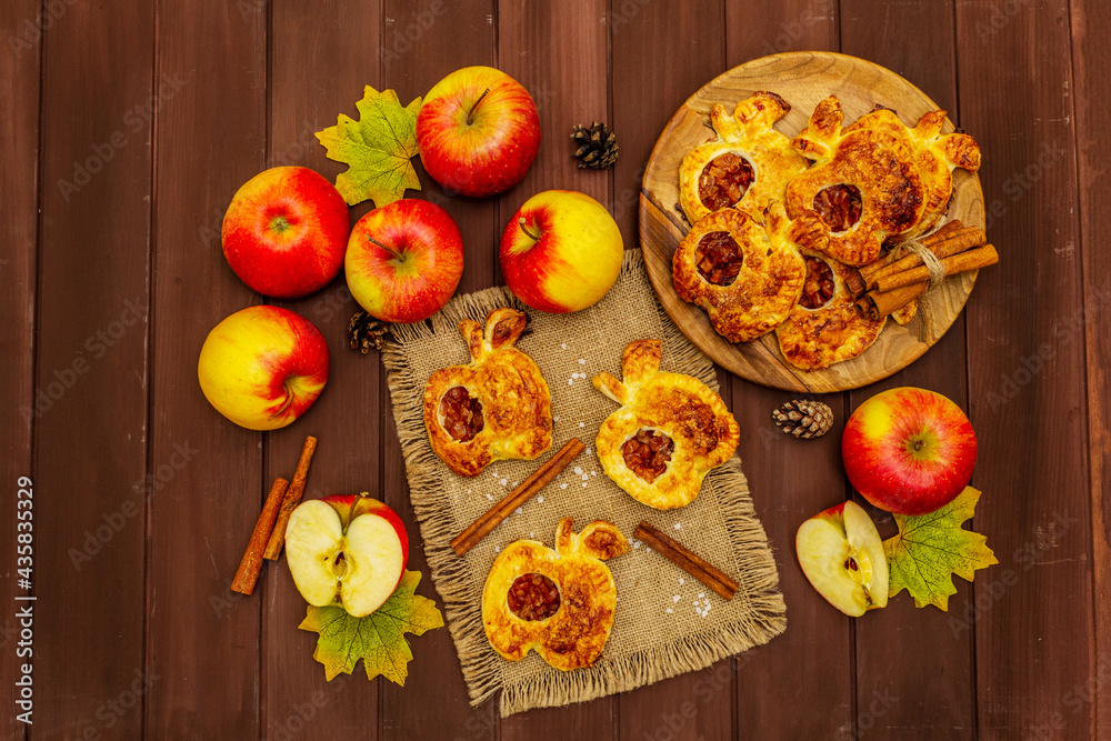 Homemade apple dessert, portioned puffs with fragrant cinnamon sticks, colorful foliage, autumn good mood Homemade apple dessert, portioned puffs with fragrant cinnamon sticks, colorful foliage, autumn good mood