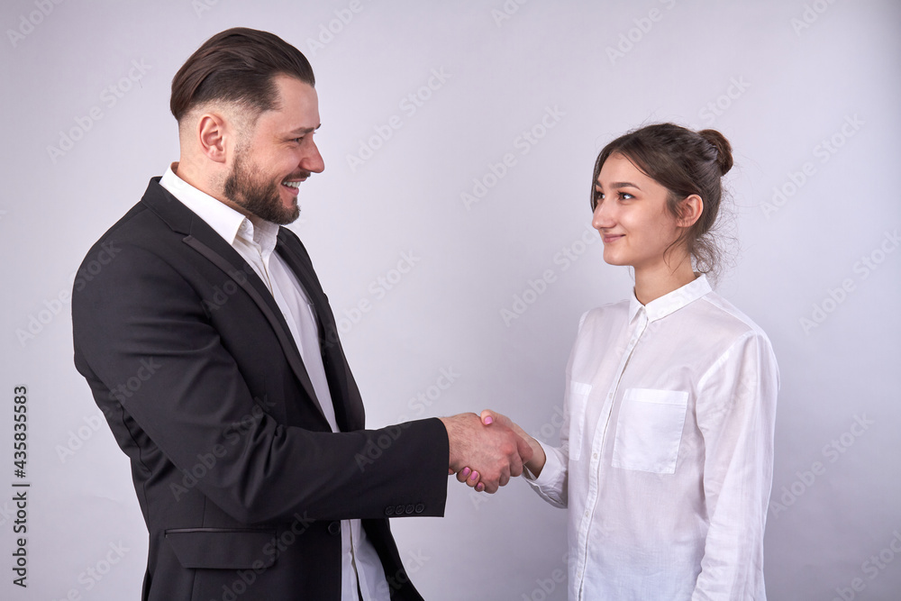 Smiling businessman handshaking with businesswoman isolated on white. Smiling businessman handshaking with businesswoman isolated on white.