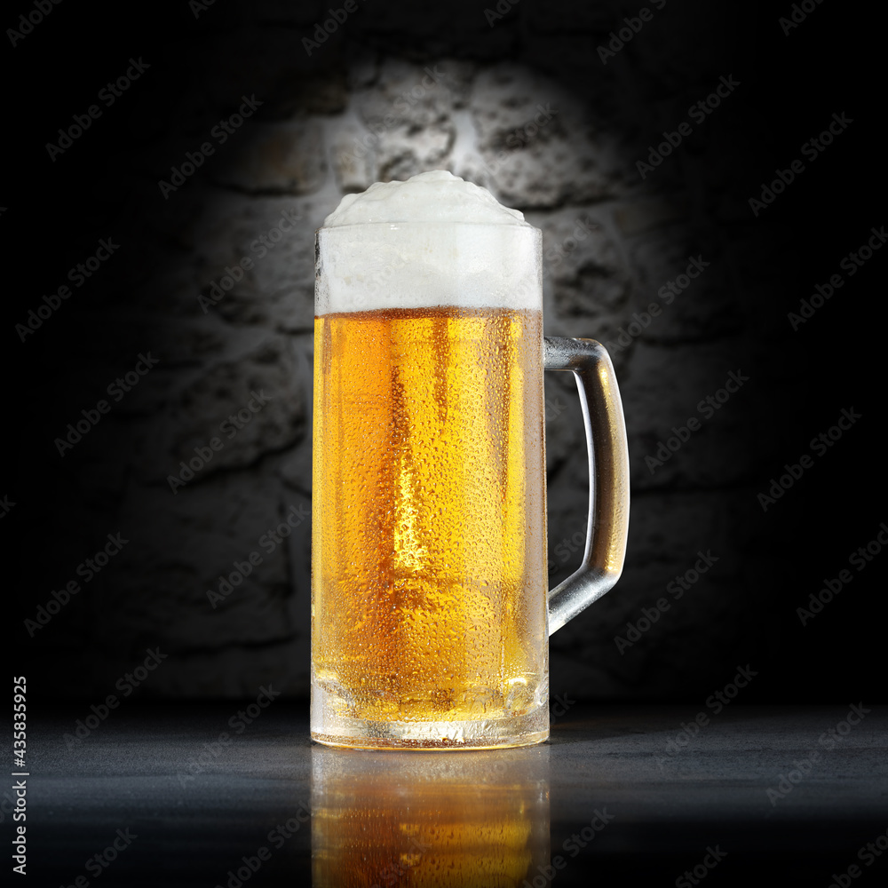 Cold beer on desk and dark background with shadows. 