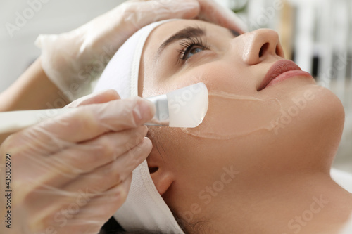 Fotografie Young woman during face peeling procedure in salon, closeup