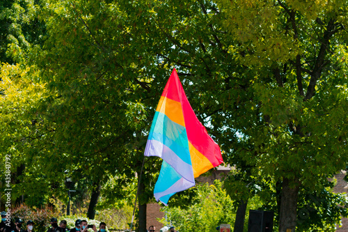 LGBT flag waving in the city's park. Protest. Support. Supportive. Equality. Human rights. Solidarity. Gender. Diversity. Community. Friendly. Relationship. Family