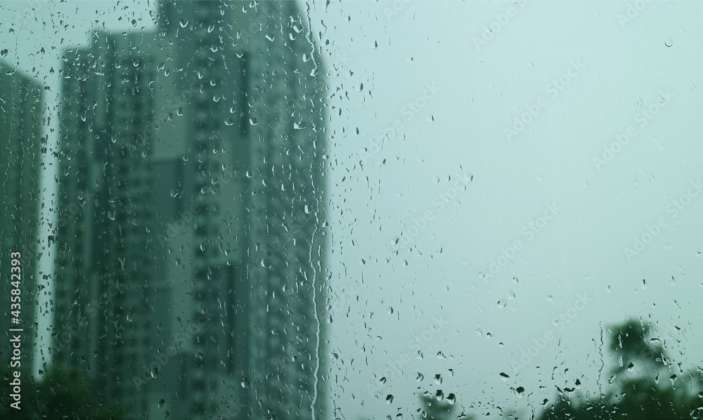Closeup the texture of rain drops on window glass with blurry skyscrapers and overcast sky in background Closeup the texture of rain drops on window glass with blurry skyscrapers and overcast sky in background