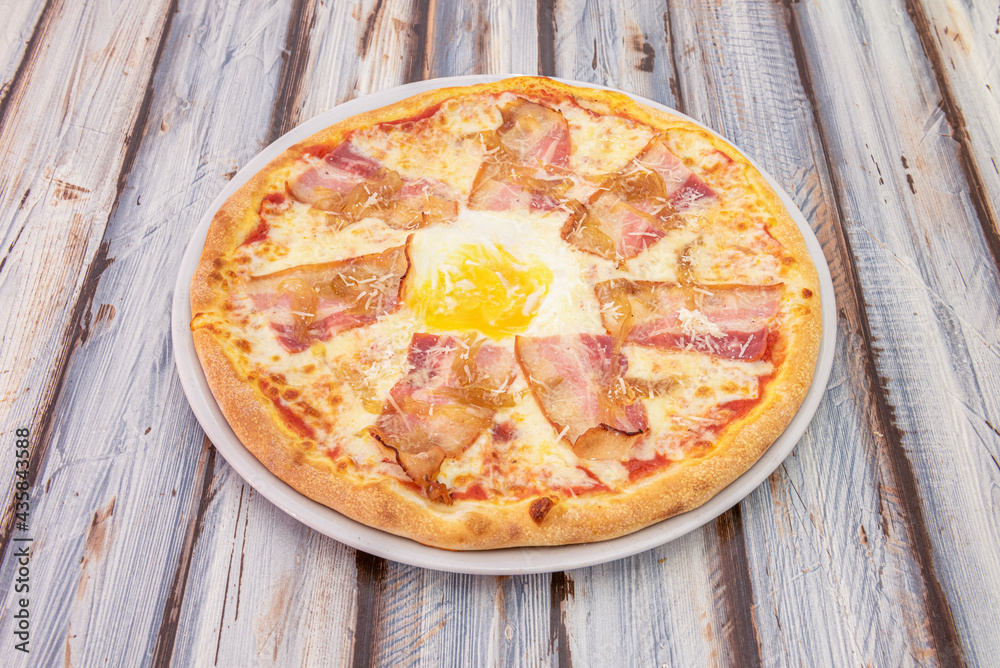 Bacon and egg pizza with mozzarella cheese and grated cheese on top Bacon and egg pizza with mozzarella cheese and grated cheese on top