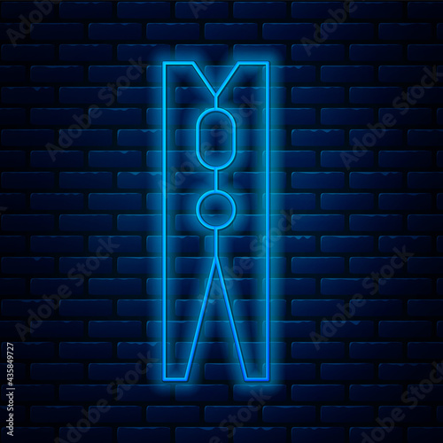 Glowing neon line Old wood clothes pin icon isolated on brick wall background. Clothes peg. Vector