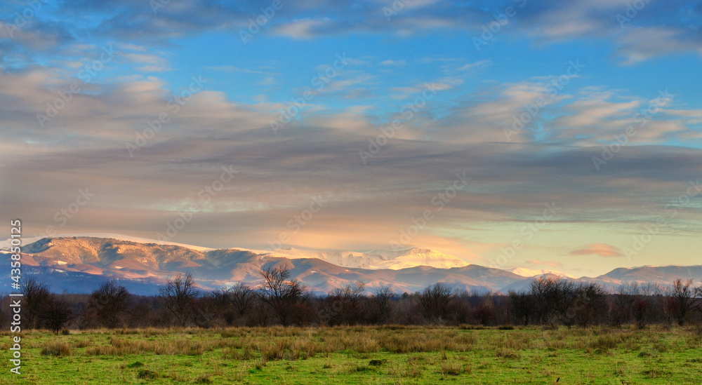 Obraz premium Snow covered mountain peaks in sunset. Location is Tarcu Mountains in Romania