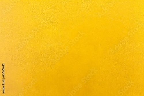 Cement wall painted yellow texture and background seamless