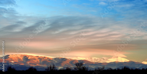 Snow covered mountain peaks in sunset. Location is Tarcu Mountains in Romania photo