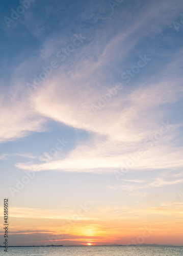 Sunset sky vertical over sea in the evening with colorful orange sunlight horizon sky, dusk sky background