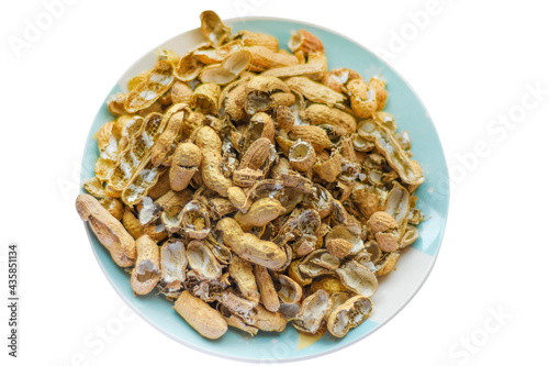 A pile of peanut shells in a plate. Closeup of leftover food in soft focus. Isolated with clipping path
