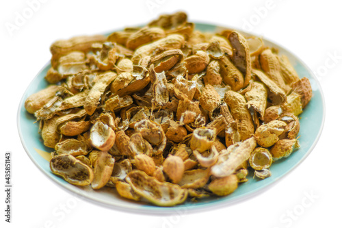 A pile of peanut shells in a plate. Closeup of leftover food in soft focus.