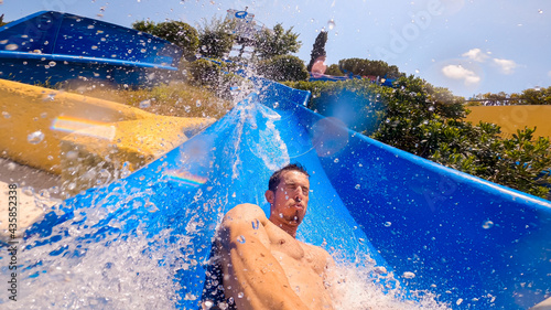 Tableau sur toile Selfie of a caucasian man sliding a water slide very fast, crashing and splashing into the pool