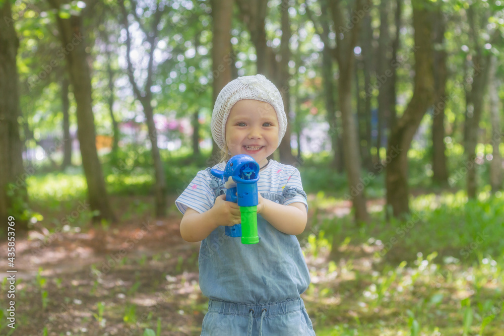 Baby girl in the summer in the park blows soap bubbles Baby girl in the summer in the park blows soap bubbles