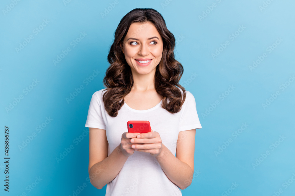 Photo of pretty adorable young lady dressed white outfit writing modern gadget looking empty space isolated blue color background Photo of pretty adorable young lady dressed white outfit writing modern gadget looking empty space isolated blue color background