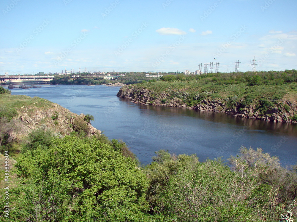 View from the thickets of the forest on the opposite shore to the rocky shores of the island of Khortytsia washed by the waters of the old Dnieper.