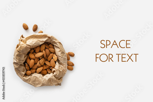 almonds in craft paper, keto food, on white background, top view, empty space for text