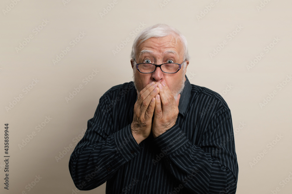 elderly gray-haired man with a beard in glasses and a black shirt covered his mouth with his hands, scared, emotions in the frame, waist portrait, light background, studio elderly gray-haired man with a beard in glasses and a black shirt covered his mouth with his hands, scared, emotions in the frame, waist portrait, light background, studio