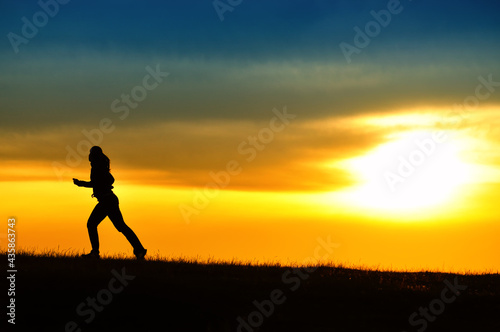 Fototapeta Naklejka Na Ścianę i Meble -  Silhouette of girl running in sunset