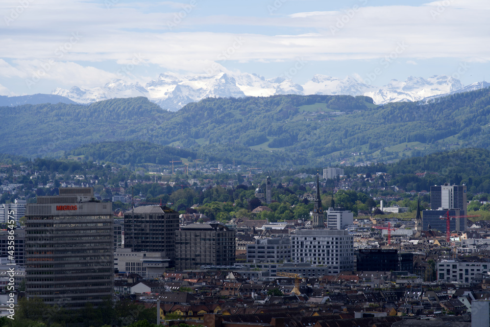 Zurich skyline at springtime with mountains in the background. Photo taken May 26th, 2021, Zurich, Switzerland. Zurich skyline at springtime with mountains in the background. Photo taken May 26th, 2021, Zurich, Switzerland.