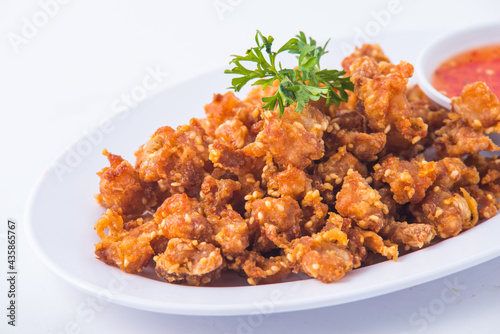 Thai crispy fried chicken on white plate.