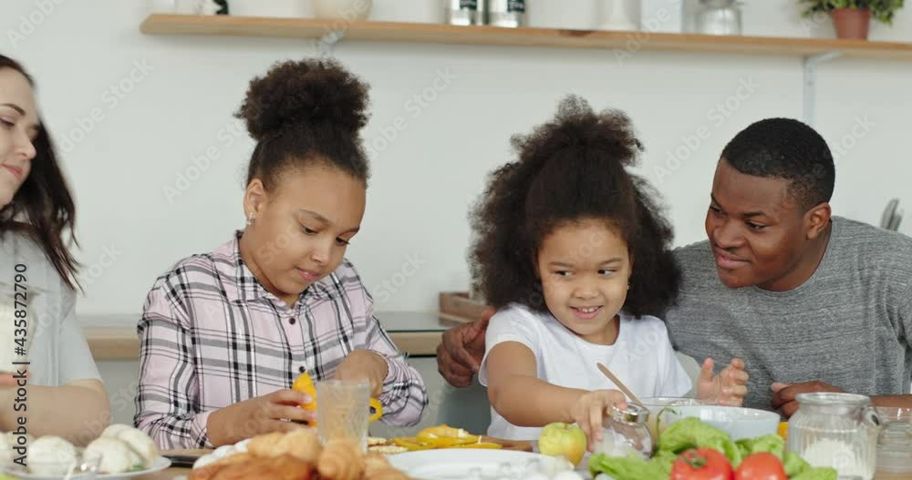 Happy multiracial family preparing breakfast together Happy multiracial family preparing breakfast together