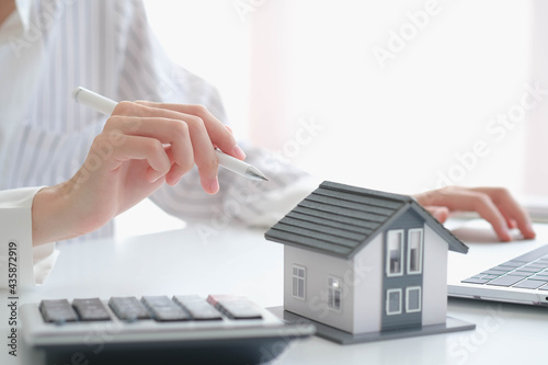 Canvas Print close up hand with house model for real estate check and summary expense of home loan mortgage for refinance plan, insurance or loan real estate