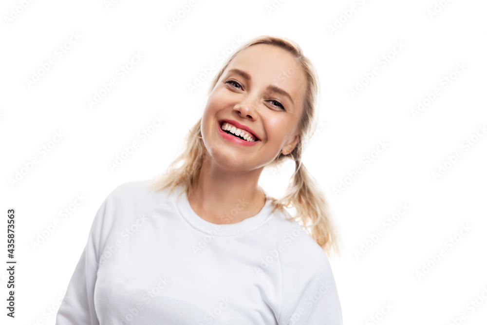 Young woman laughs. Pretty blonde with ponytails in a white sweater. White background. Young woman laughs. Pretty blonde with ponytails in a white sweater. White background.