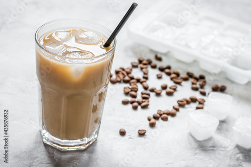 coffee break with cold iced latte and beans on stone table background
