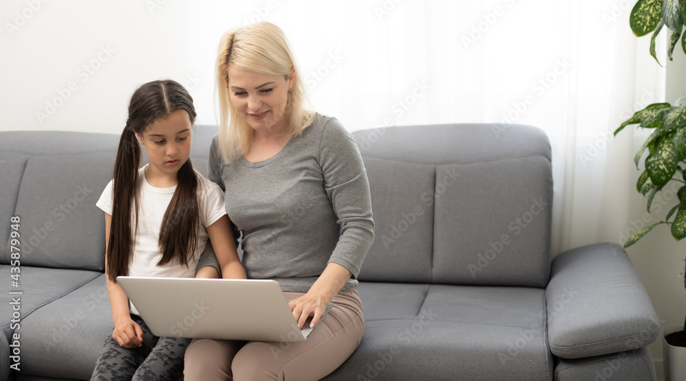 Young woman with girl using laptop computer Young woman with girl using laptop computer