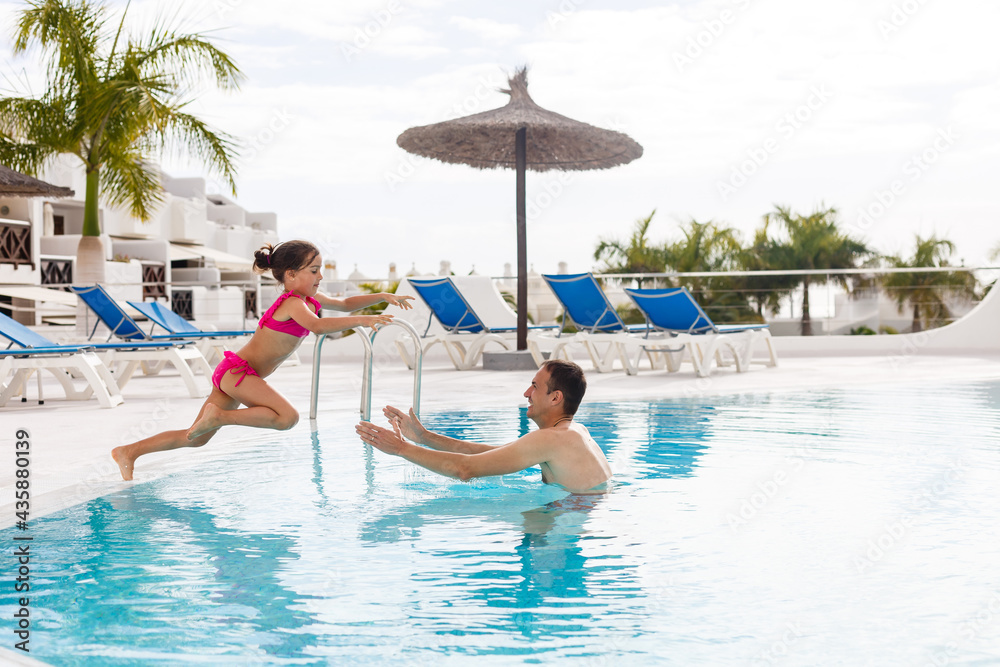 Father playing with his daughter in swimming pool