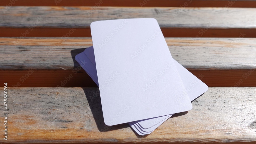 Blank playing card mock up. Deck of white cards on a wooden background Blank playing card mock up. Deck of white cards on a wooden background